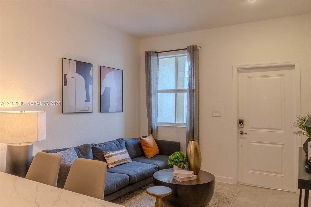 Neutral wall tones, single-hung window with drapery, and a white interior door featuring a raised panel design