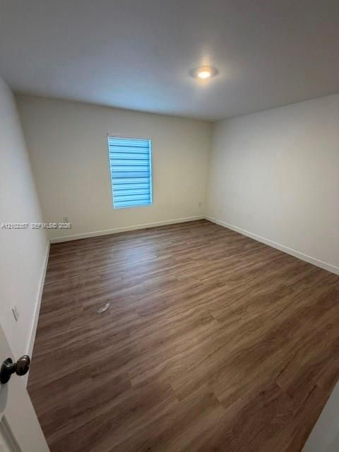 Wood-finish flooring, neutral wall tones, recessed ceiling lighting, and a window featuring adjustable horizontal blinds