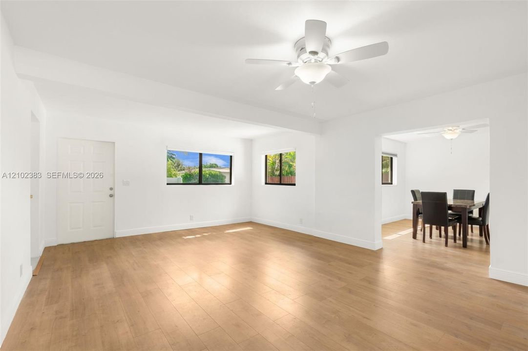 Family roomfeaturing wood-finish flooring, white walls, and a ceiling fan with integrated lighting