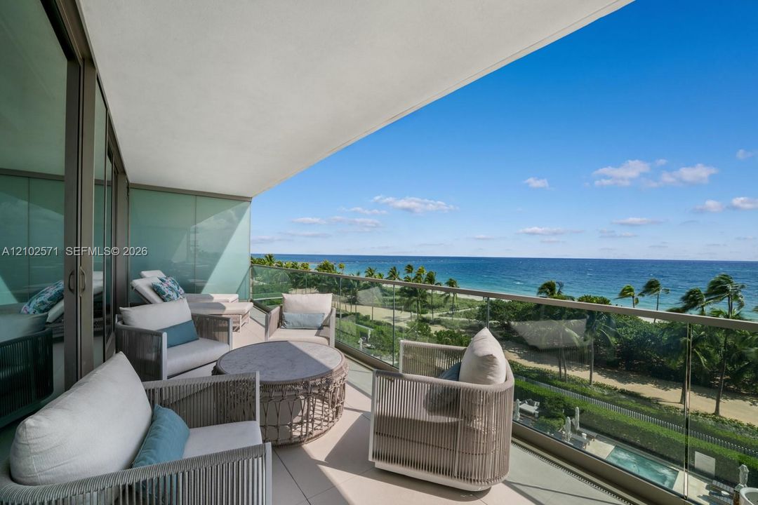 Covered balcony featuring a glass panel railing, tiled flooring, and floor-to-ceiling glass sliding doors