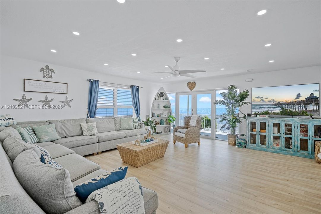Spacious living area featuring wood-finish flooring, recessed lighting, a ceiling fan, and sliding glass doors opening to the exterior