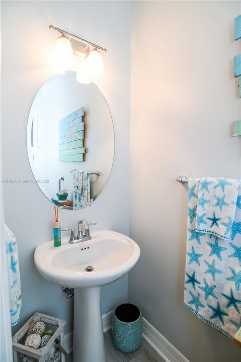 Deep navy accent wall, single-hung window with horizontal blinds, and wood-finish flooring