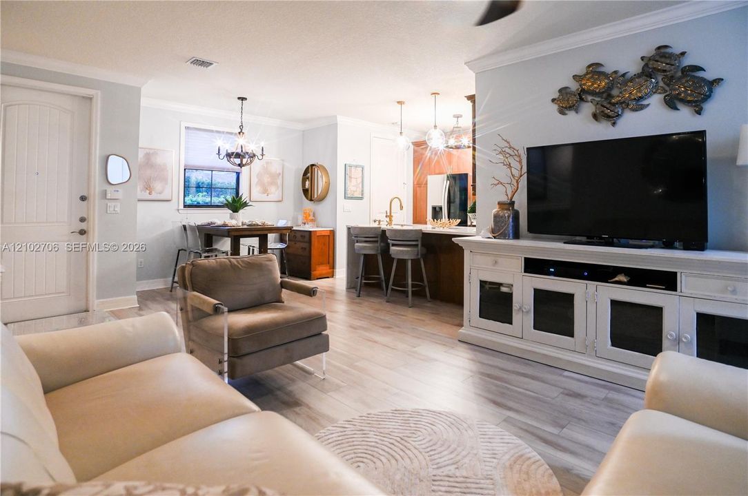 First floor primary. Neutral color palette featuring light-toned wood-finish flooring and an integrated window with natural light