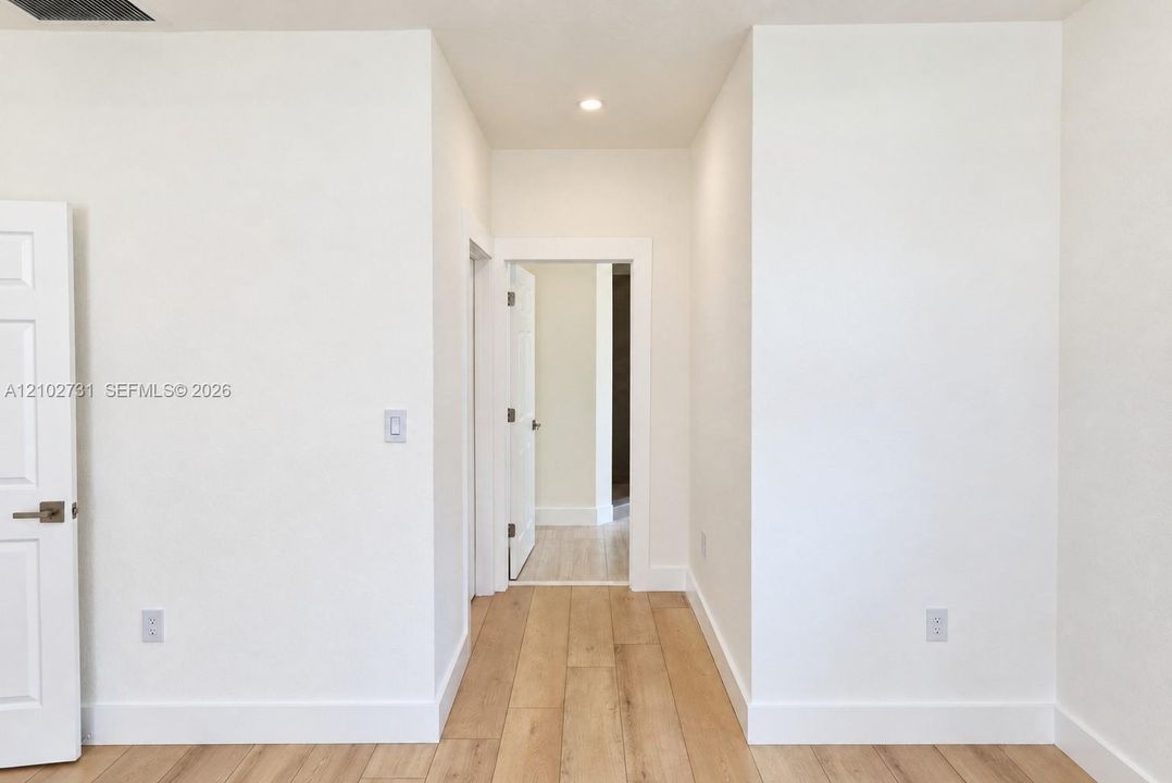 Neutral-toned walls, light-finished wood-finish flooring, recessed lighting, and white multi-panel doors with satin nickel hardware