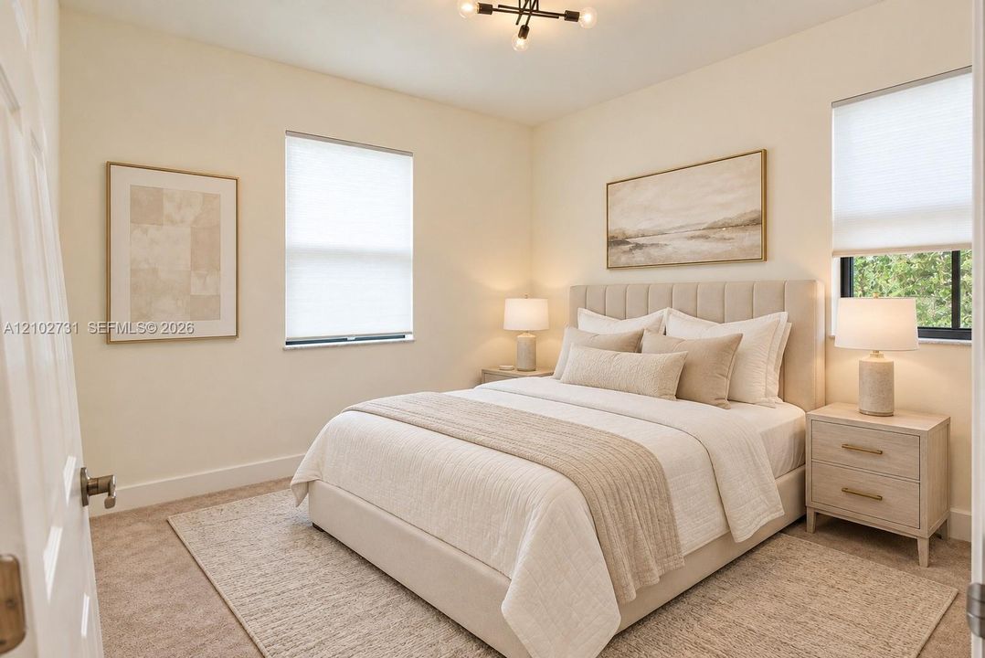 Neutral-toned room featuring wall-to-wall carpeting, dual windows equipped with pleated shades, and an exposed-bulb modern geometric ceiling light fixture