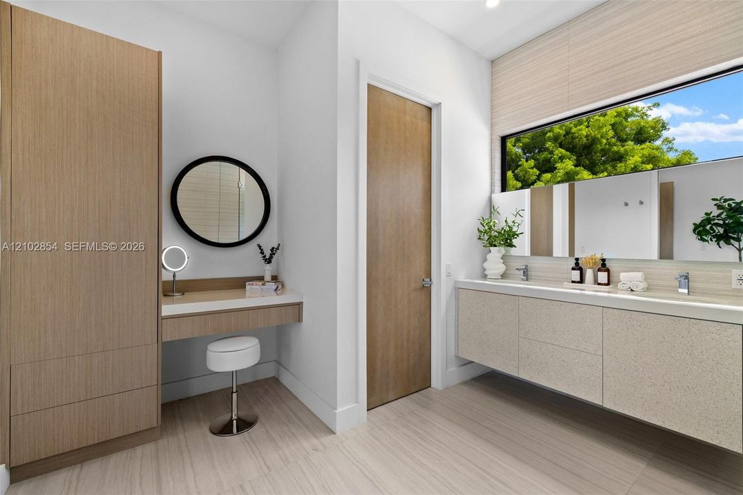 Bathroom featuring a floating double vanity with a stone countertop, integrated cabinetry with a built-in vanity station, recessed lighting, and large horizontal window
