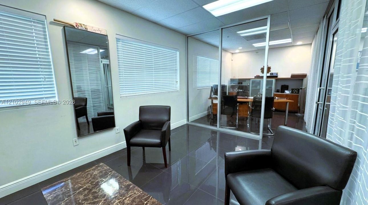 Office First Level space featuring gloss-finish tile flooring, recessed ceiling lighting, horizontal window blinds, and a glass-paneled partition wall