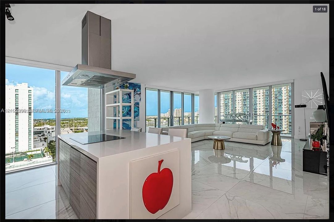 Full-height window walls, white gloss tile flooring, a kitchen island with cooktop, stainless steel range hood, and modern cabinetry