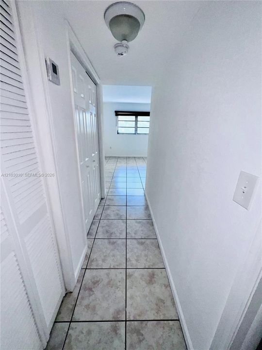Neutral-toned ceramic tile flooring, dual-panel closet doors, and flush-mount ceiling lighting