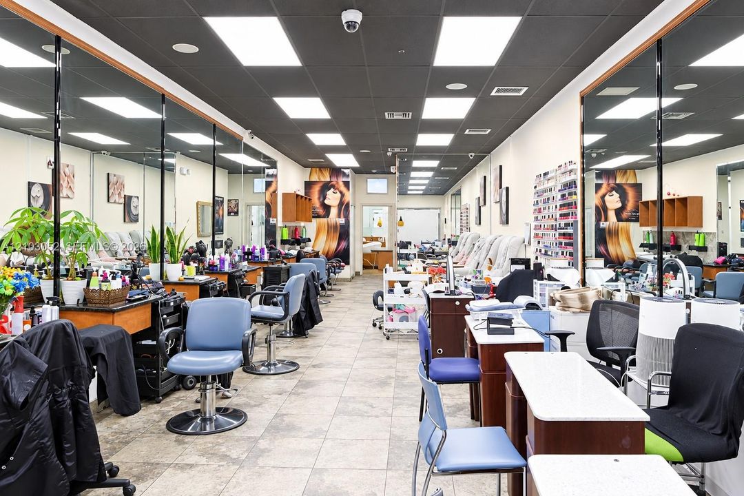 Commercial space featuring wall-to-wall mirrors, recessed lighting, tile flooring, and integrated display shelving