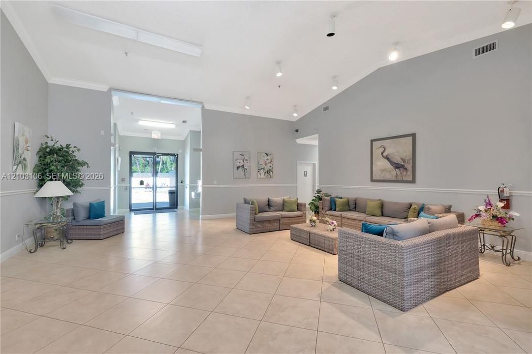 Spacious interior area featuring high vaulted ceilings, large-format tile flooring, recessed lighting, and chair rail molding