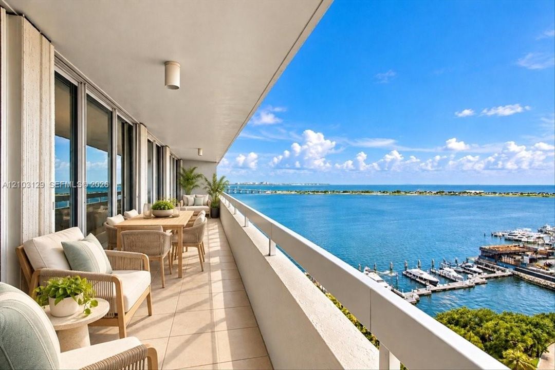 Covered balcony featuring expansive tile flooring, a high-gloss ceiling finish, and a full-length metal railing overlooking the water