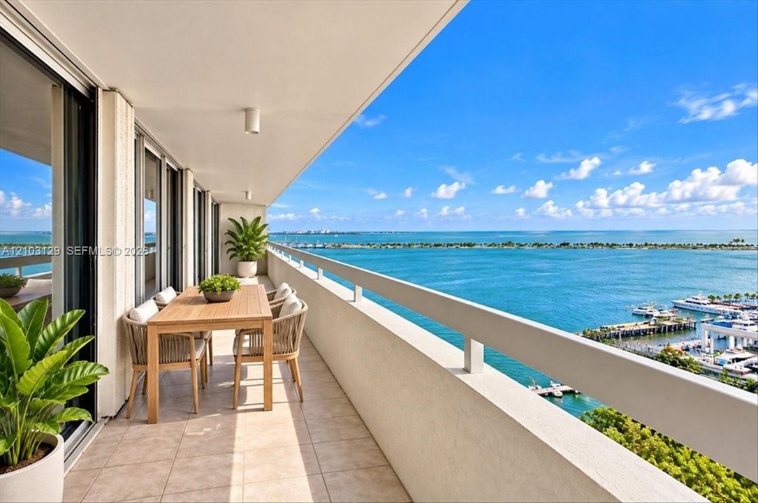 Expansive covered balcony featuring tile flooring, metal railings, and direct water and marina scenery