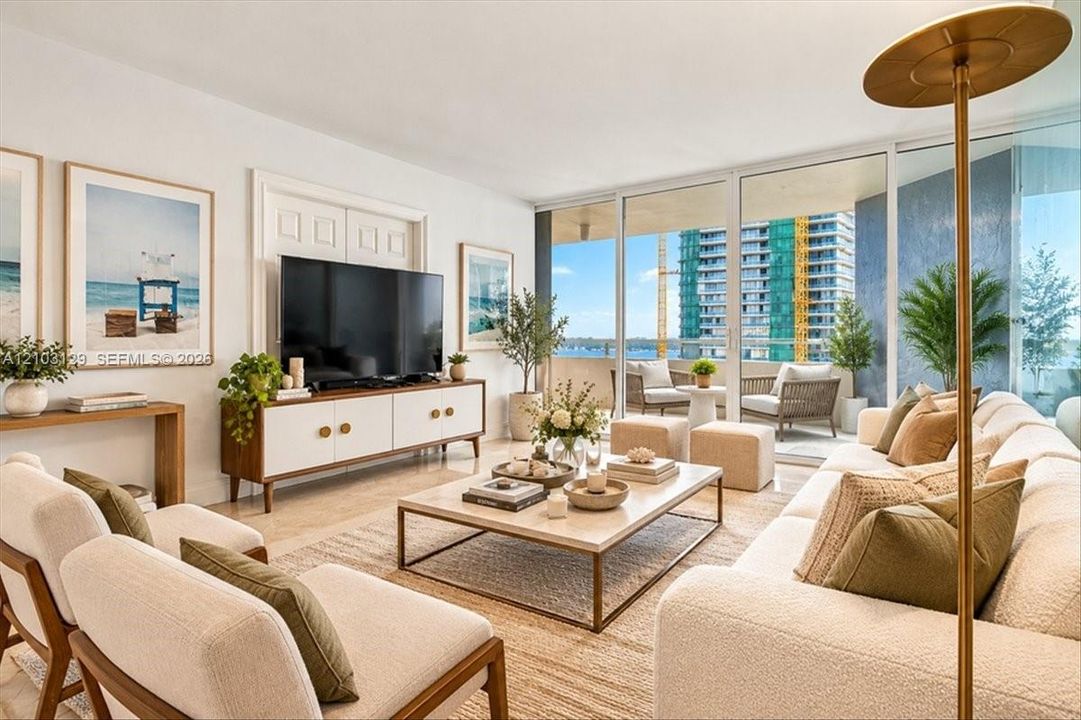 Living area featuring floor-to-ceiling glass sliding doors, stone-finish flooring, and an expansive covered balcony