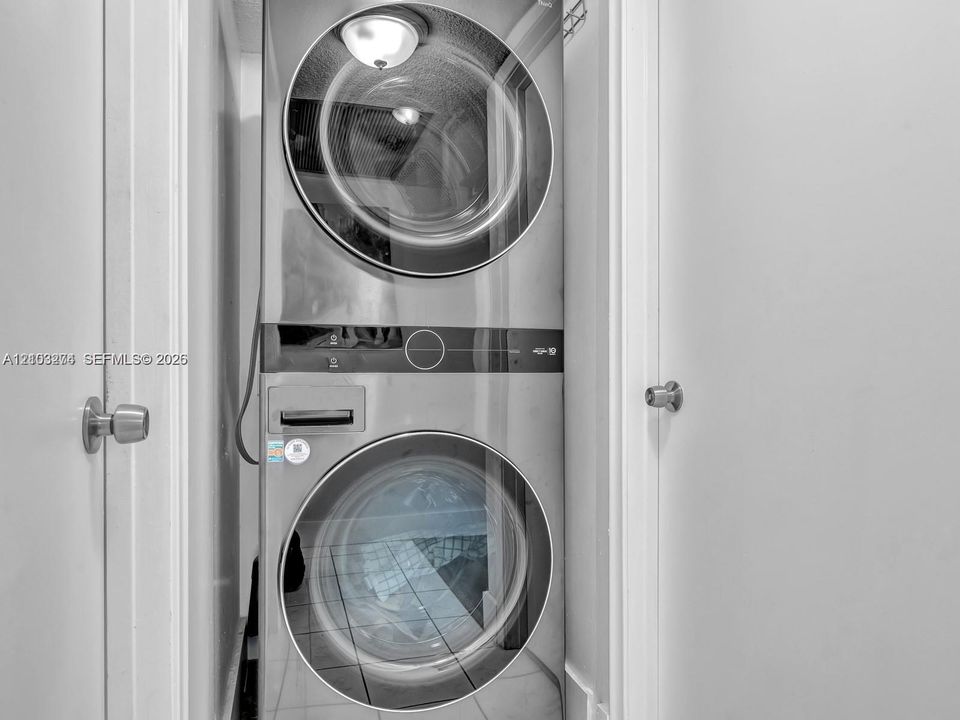 Stacked stainless steel front-load laundry unit with circular glass doors