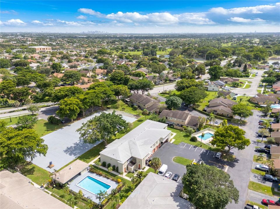 Expansive property featuring multiple buildings, two outdoor swimming pools, and extensive paved parking areas