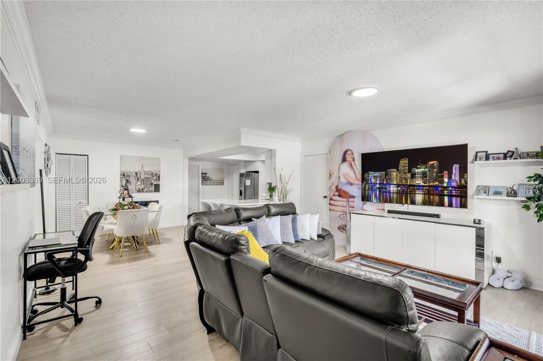 Recessed lighting, light wood-finish flooring, white walls, and a built-in media console