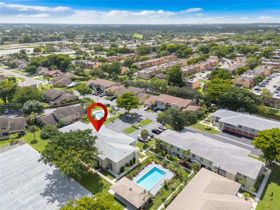 Community featuring multiple buildings, surface parking areas, and two distinct swimming pools