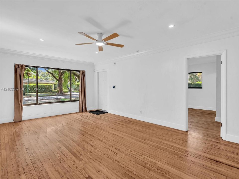 Living room view featuring wood-finish flooring, crown molding, recessed lighting, and a ceiling fan. House for rent in Coral Gables. House for rent listed by Realtor.