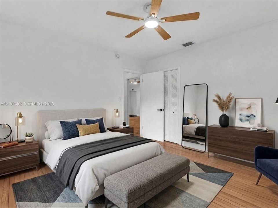 VIRTUAL STAGING. East bedroom featuring wood-finish flooring, a ceiling fan with integrated lighting, and louvered-panel closet doors. House for rent in Coral Gables. House for rent listed by Realtor.