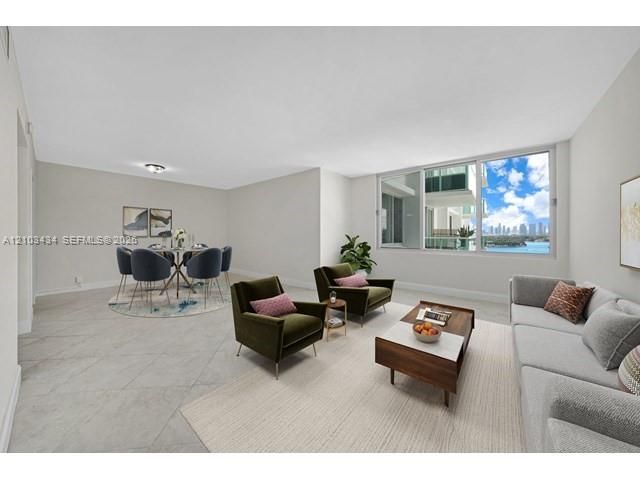 Open-concept interior featuring large-format tile flooring, neutral wall tones, and expansive windows with balcony access