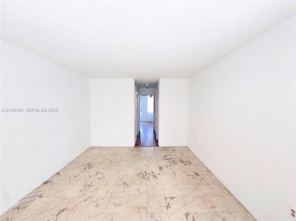 Interior space featuring high-contrast neutral wall finishes and large-format tile flooring with marble-pattern detailing