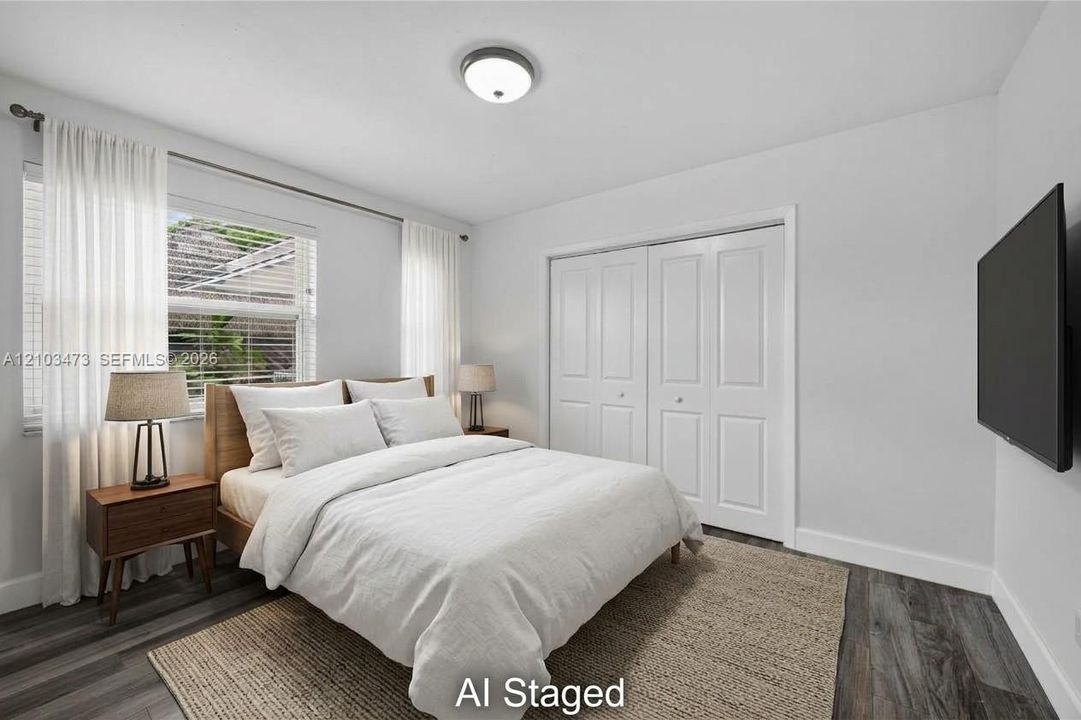 Wood-finish flooring, overhead flush mount light, and bi-fold closet doors