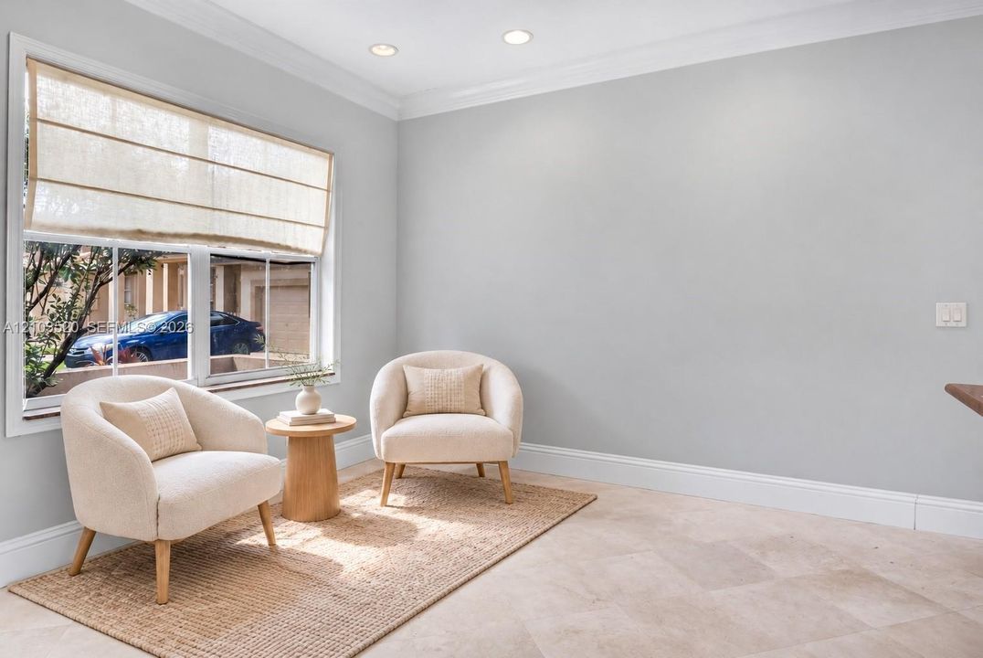 Neutral-toned interior space featuring light-colored tile flooring, crown molding, and recessed lighting