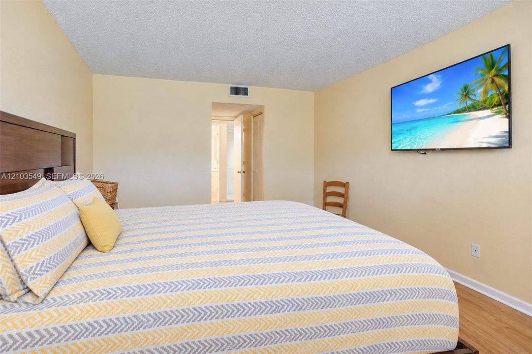 Neutral wall-to-wall interior paint, wood-finish flooring, and recessed ceiling texture
