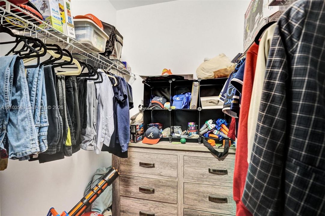 Walk-in closet featuring wire shelving and neutral wall finishes