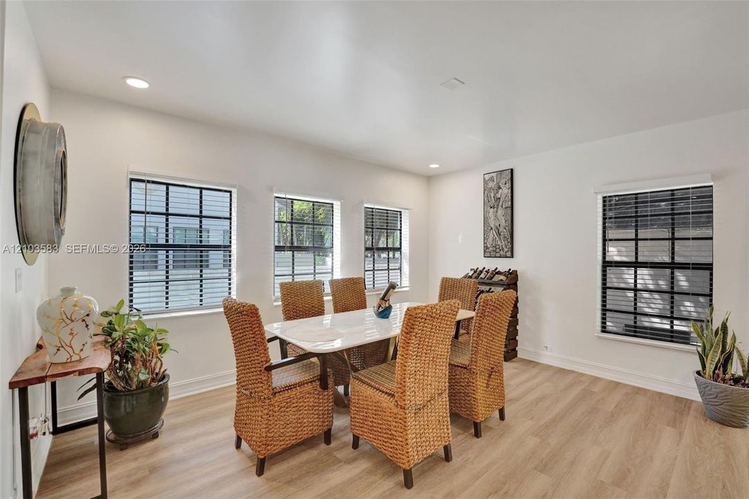 Dining area featuring wood-finish flooring, recessed lighting, and multiple windows with black muntin detailing
