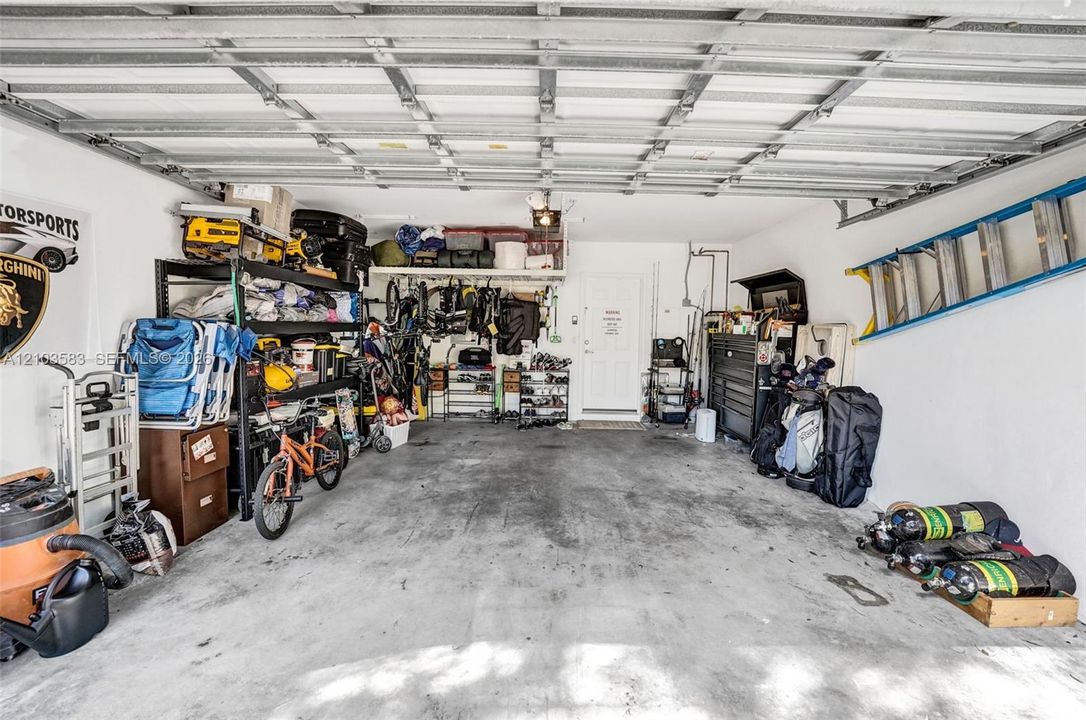 Attached garage featuring a concrete floor, painted interior walls, and an exterior entry door