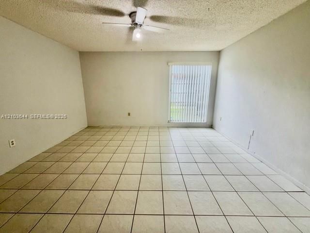 Tile flooring, ceiling fan, window with vertical blinds