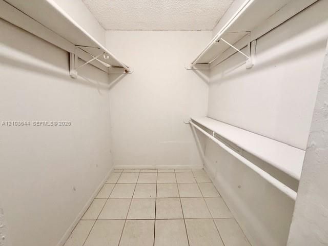 Walk-in closet featuring dual shelving and clothing rods