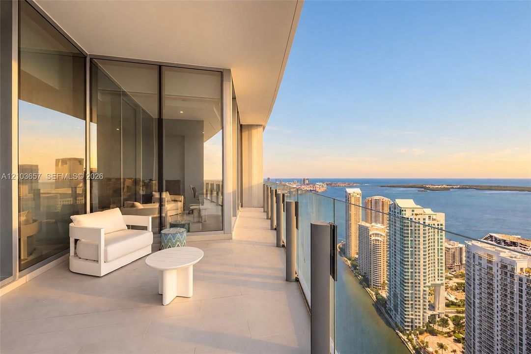 Expansive private balcony with a glass railing and tile flooring