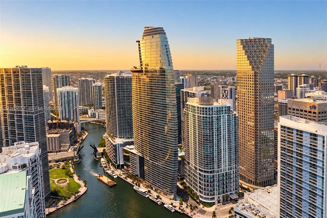 High-rise buildings with contemporary glass and concrete exteriors, urban waterway, surrounding cityscape, and distant horizon