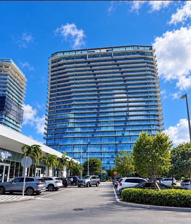 High-rise residential tower featuring a glass facade, private balconies, and concrete structural elements