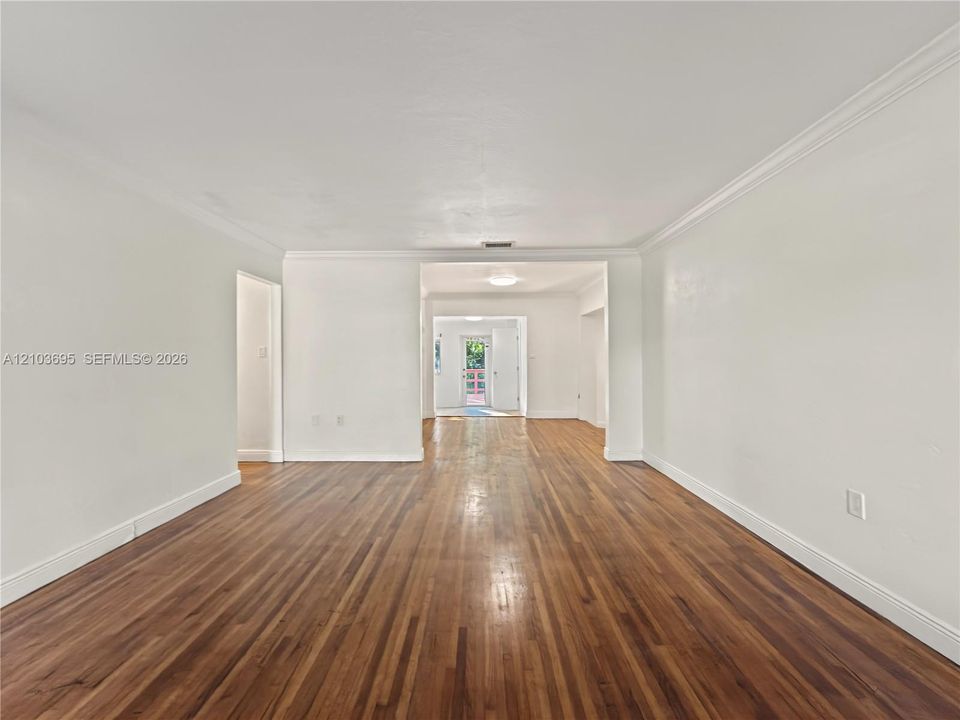 Interior space featuring wood-finish flooring, crown molding, and neutral wall paint