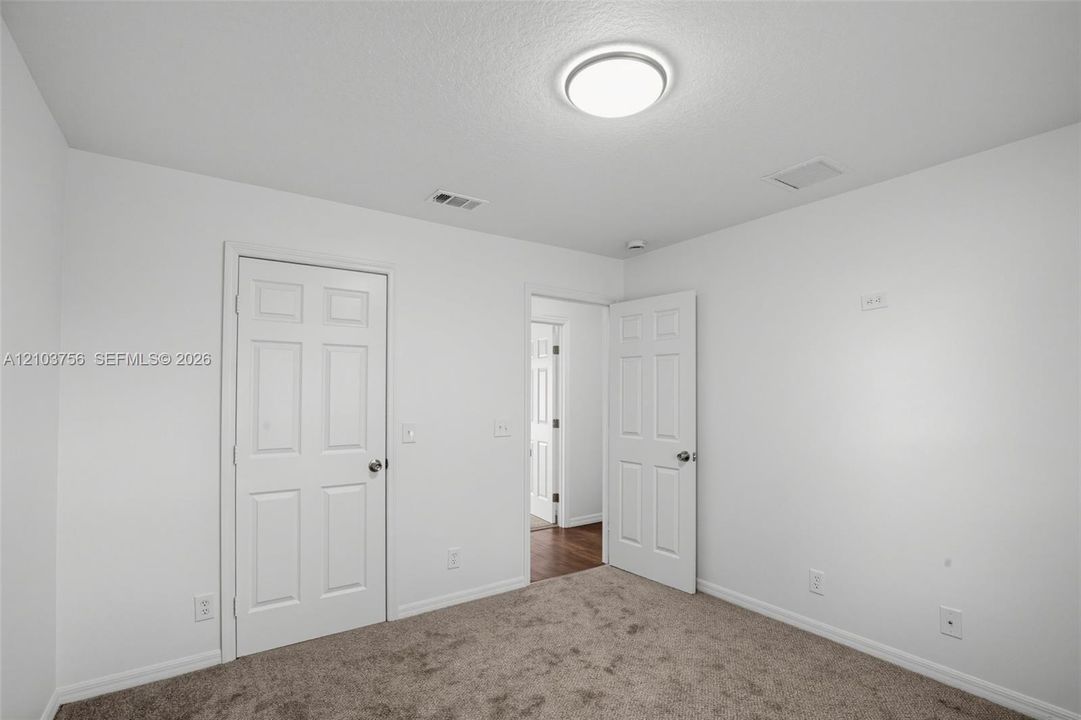 Neutral-toned carpeting and six-panel interior doors with brushed metal hardware