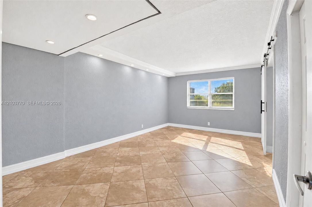 Recessed lighting, tile flooring, crown molding, double-pane window, barn door