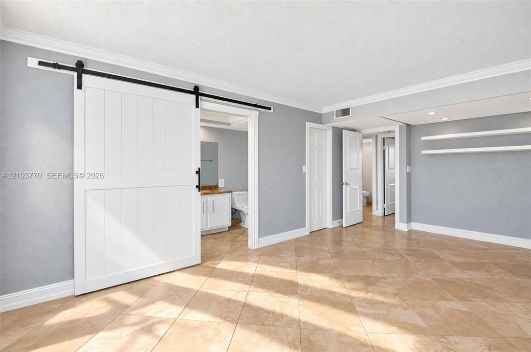Wood-finish flooring with crown molding and white baseboards