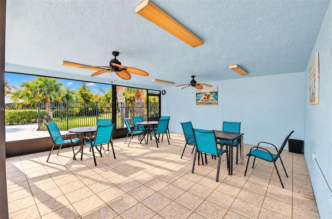 Screened enclosure with tile flooring and multiple ceiling fans