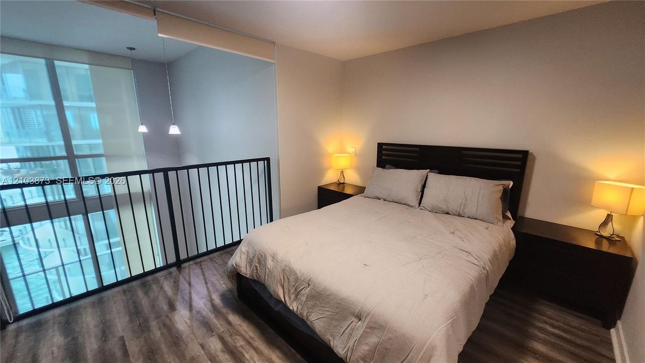 Wood-finish flooring, floor-to-ceiling windows, and a metal safety railing