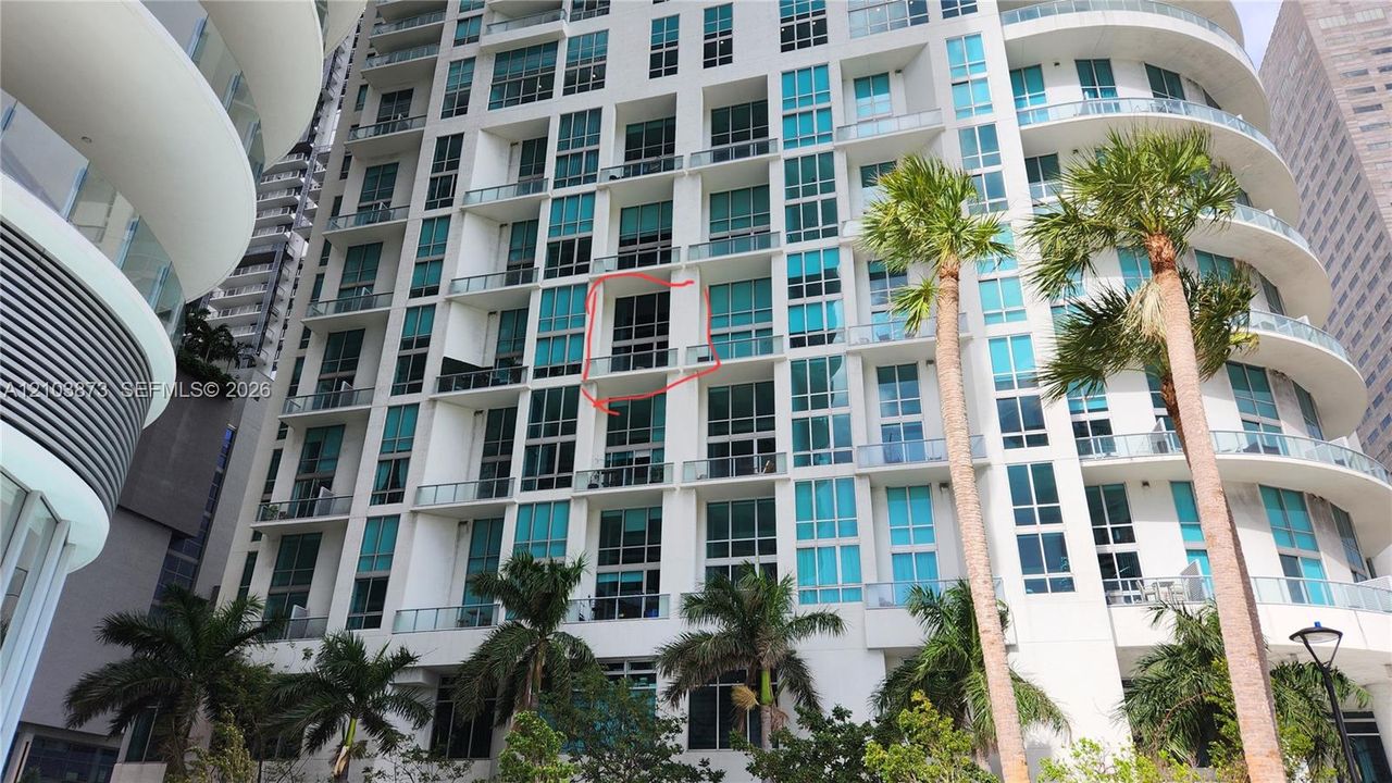High-rise exterior featuring floor-to-ceiling glass windows and private balconies with glass railings