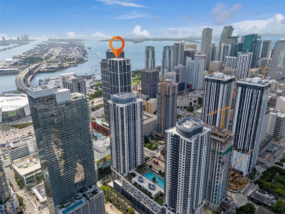 High-rise residential tower featuring a glass facade, podium-level swimming pool, and proximity to the waterfront and urban infrastructure