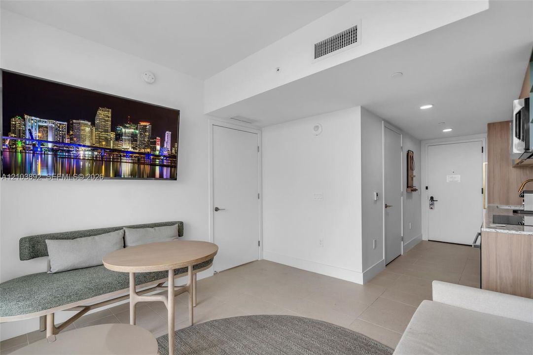Neutral tone interior featuring large-format tile flooring, flat-panel wood-finish cabinetry, and recessed lighting