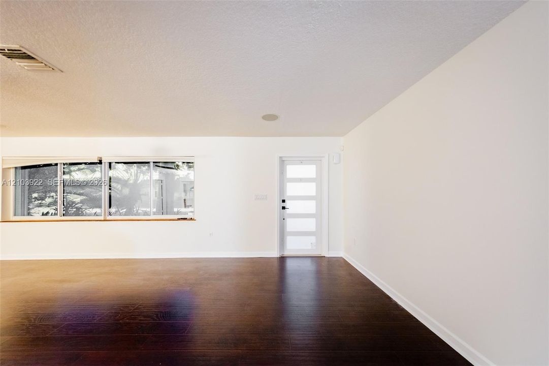 Dark wood-finish flooring with white walls