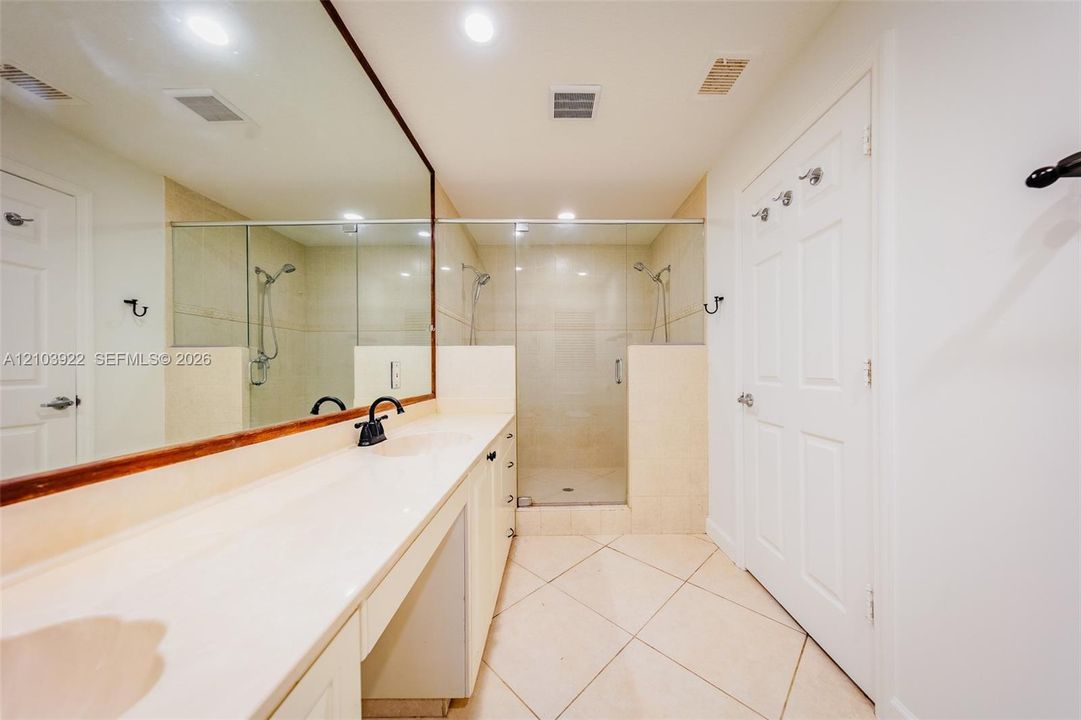 Expansive vanity with integrated countertop, full-width mirror, and matte black fixture