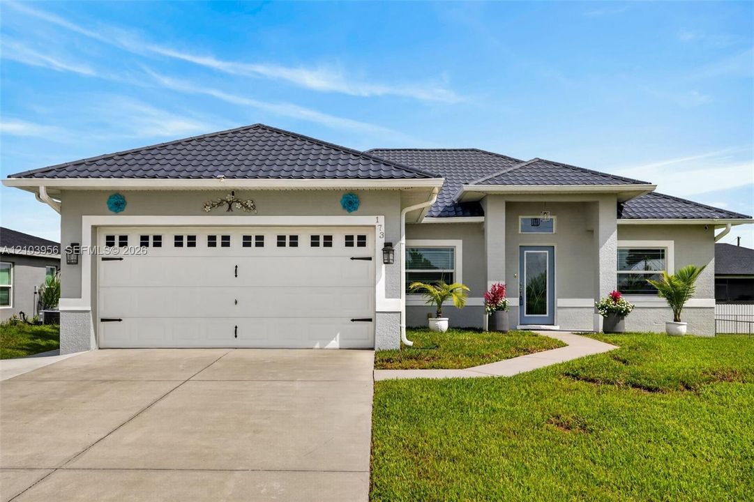 Single-story residence featuring a tile roof, light gray exterior, and an attached two-car garage