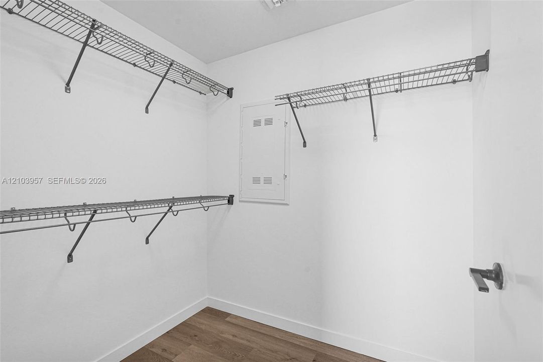 Wood-finish flooring, white walls, and wire shelving system